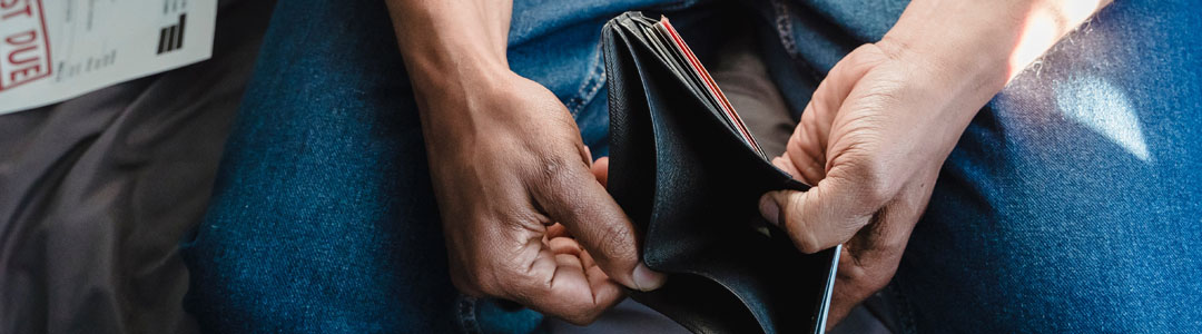 A person holding open an empty wallet.