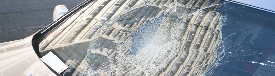 The smashed windscreen of a white car.