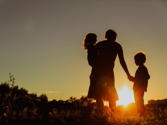 Silhouette of woman and two kids.