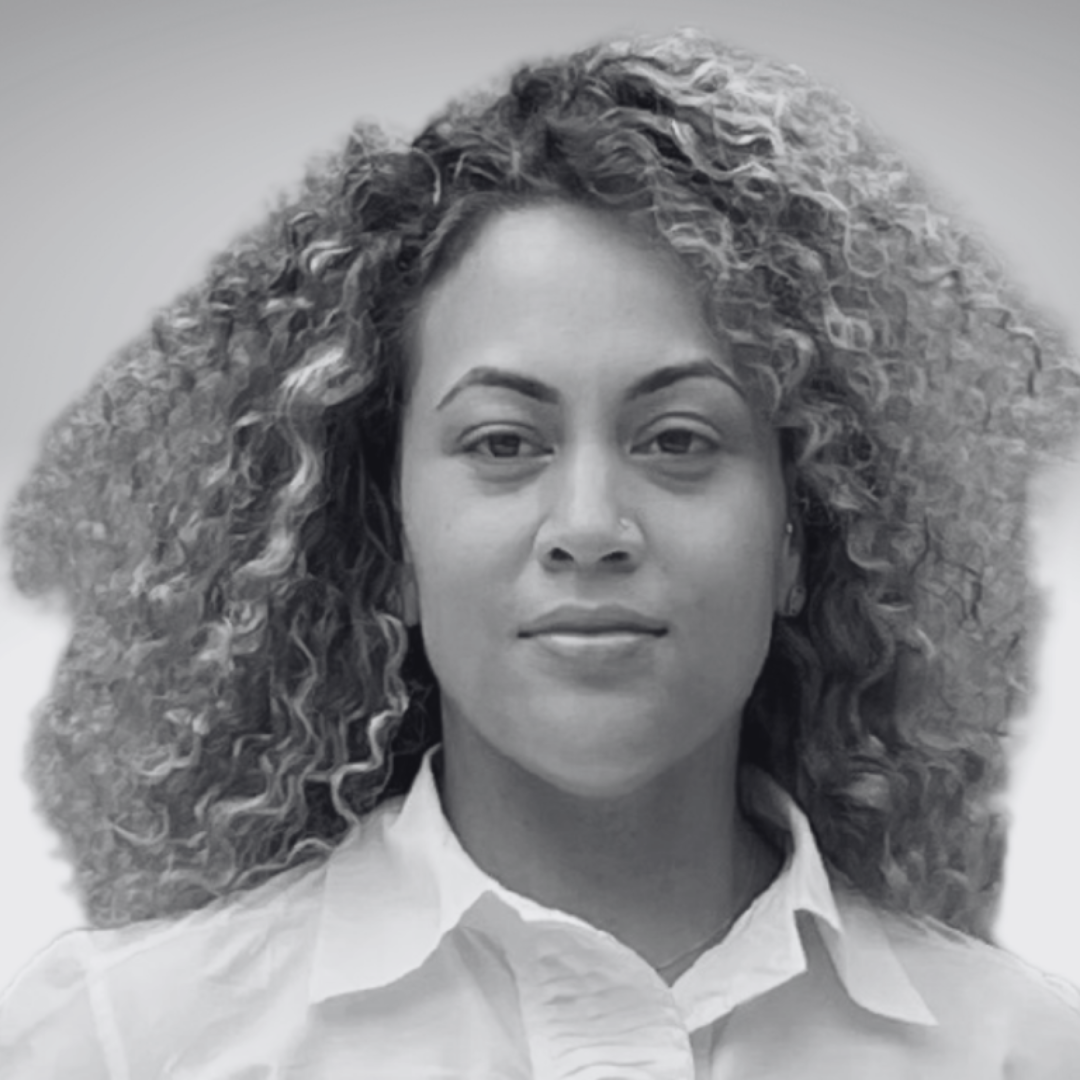 Headshot of Allienttia Weldon-Oti smiling slightly. She has curly hair and wears a white shirt.