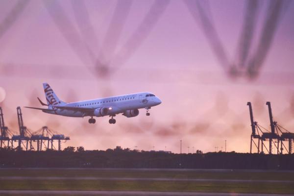 A place takes off at Brisbane airport at sunset.