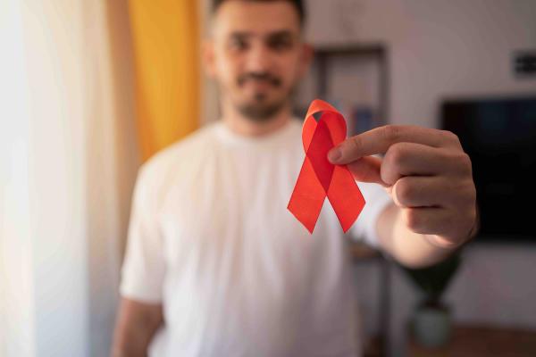 Man holds an HIV ribbon.