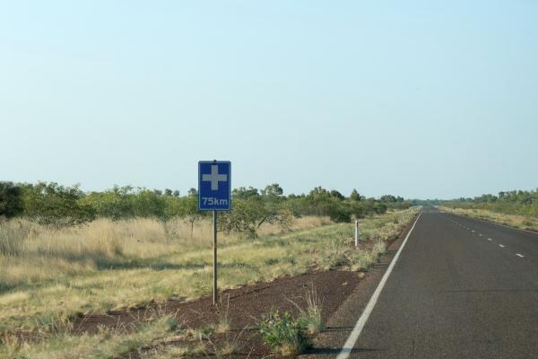 A road sign with a health symbol on a rural road.