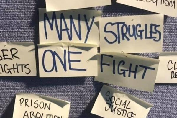 A post it board with the words 'Many struggles, one fight'.