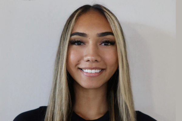 Headshot of Maikiira Barber smiling. She has long hair and is wearing a black t-shirt.